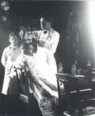 Sällbergs Frisérsalong i Solstadström.

Frisörmästare Ivan Sällberg klipper en kund, Isac Karlberg, Blankaholm, med brodern Sven Sällberg, 12 år och tvålpojke i frisersalongen, tittar på.

Stolarna i saöongen tillverkade och köpta av Mörtfors Möbelfabrik