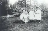 Bilden tagen innanför stenmuren vid grindstugan under Späckemåla i Misterhult socken. Linnéa Swahnberg med barnen Gunnar, Margit, Dagny.