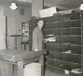 Brevbärarexpeditionen i Sundsvalls postkontor, försortering av korsband. Brevbärarförman E. Höglund.