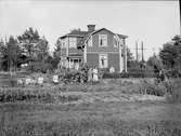 Bostadshus med barn och vuxna i trädgården, Stjärnlund, Gammelbyn, Uppland