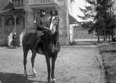 Handlare Petterssons dotter med häst året 1931 framför en ännu kvarstående villa på Syréngatan på Sommaro.