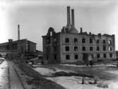 Skattkärrs Kakelfabrik i ruiner efter förödande brand 1920. I bakgrunden tegelbruket
