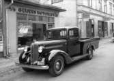 En lätt lastbil av märket Plymouth Fargo utanför Geijers Motoraffär på Herrgårdsgatan 17 i kvarteret Enigheten. Bilden tagen 1938.