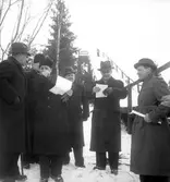 Välklädda funktionärer vid dagens tävlingar i backhoppning år 1938. Backen låg vid Svinbäcksbergets branta avslutning mot norr.
