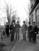 Grupp med herrar, med J P Nyström själv längst till höger, poserande vid ingången till bostaden och orgelfabriken i hörnet Västra Kanalgatan–Norra Strandgatan i slutet av 1890-talet