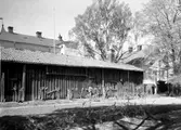 Ekonomibyggnader inne i kvarteret Almen på en bild från 1933. Längan och stenhuset bakom revs inför stadshusbygget.