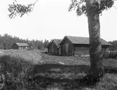 Fagersta fäbodar där man ser en fäbolaladugård och en hölada i förgrunden. I bakgrunden syns en fäbostuga och allt detta under begynnande förfall.
