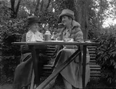 Hanna Olsson till höger underhåller sig med en okänd dam vid kaffebordet.