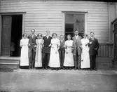 Här är en samling släktingar som står utanför lägenheten på 3:e Tvärgatan 15. Personerna från vänster: Ingeborg Olsson med uppvaktning, förmodligen Anna Larsson från Hemlinggrind, Elnas bror Einar Olsson och Naemi Olsson, Adde och Hildur Holmstedt, David och Elna Brundin samt Davids bror Josef Brundin. Jämför bild nr EB 679.