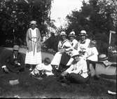 En grupp personer, bland andra Elna Brundin med sina döttrar omkring sig och vänner till Elna. Foto ca 1920.