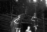 Lilian Holmstedt till vänster, Sören Brundin och Eva Brundin byggde en koja av brädor och granris, ca 1929.