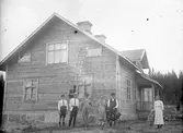 Framför huset. Tidsomfånget är 1900 - 1940