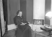 Sigrid Paues vid kakelugnen. Tidsomfånget är runt 1920.