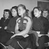 Föredragslyssnare. Bilden ingår i ett fotoalbum.
