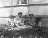 Utomhus i gräset, med hund, docka och dockvagn.