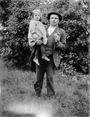 Man med flicka på armen.