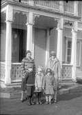 Gruppfoto av två kvinnor med tre barn framför huset.