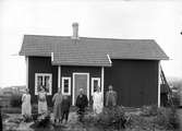 Gruppfoto på gården framför huset.