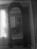 Interiör, avfotograferad spegel. I spegelbilden syns fotografen (antagligen Nanny Ekström)