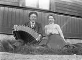 Köpman Emil Berglund och Olga Ljung (gift Berglund) med dragspelet i trädgården, Fors, Torsåker.