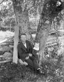 Unga man och en liten i gröngräset
