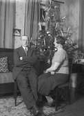 En man och en kvinna vid julgranen