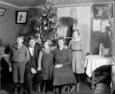 Okänd familj vid julgranen
