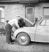 Män och pojke kollar motorn

