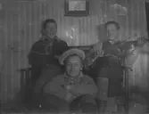 Tre män, en spelar fiol.