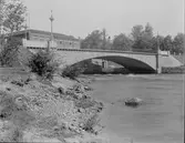 Drottningbron över Gavleån med Valskvarn i bakgrunden. Bron öppnades 1911. Den välvda betongbron, klädd med sten, blev en förlängning av Drottninggatan och fick sitt fäste vid Valskvarn och på den andra sidan vid Strömsborgs vattenverk.
