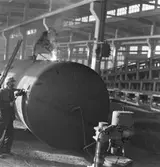 Gävle Galvan, 20 oktober 1949. Interiör av verkstad
Gavleverken AB, GA Plagan AB ursprungligen Lindahl & Runers Mekaniska Verkstad.
1893 till Gefle Verkstäder AB. 1910 ombildades till Gefle Verkstad & Gjuteri AB, 1924 till AB Gavleverken. Företaget köptes 1953 av Gävle Galvan grundare och ägare Arne Sjöström, som 1954 sålde Galvaniseringsfabriken .