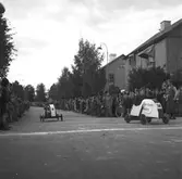 KFUM:s Pojkracertävling. September 1944. Vet ej vilket foto i serien som texten tillhör: Bo Strömberg, Sandviken: Mannen överst till höger är Bert Strömberg f 1917 död 1983. Denna lådbil fanns till mitten av 50-talet på 4:e Tvärgatan och användes av oss barn som leksak Nynäs. Bil nr 14 Norrlandsposten
