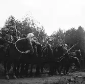 Kamratfesten på Kungsbäck. Maskeradklädda män på häst