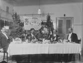 Edvard Lindbloms matvaruaffär. Julbordet står dukat.
Längst till vänster skräddarmästare Karl Nilsén och andra från höger Edvard Lindblom.
Uppgifter om namn har lämnats av Göte Nilsén
