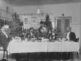 Edvard Lindbloms matvaruaffär. Julbordet står dukat.
Längst till vänster skräddarmästare Karl Nilsén och andra från höger Edvard Lindblom.
Uppgifter om namn har lämnats av Göte Nilsén
