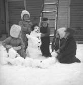 Snösvängen i Gävle. Barn bygger en snögubbe