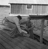 Man och kvinna vid sjöbod. Reportage från Bönan. År 1948. Reportage för Afton-Tidningen. Beställt av fru Wesslén, Bönan.