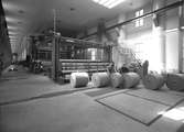Korsnäs Pappersbruk. PM 2. Det färdiga papperet framtages i stora rullar. Juni 1953. Korsnäs AB är ett av Sveriges ledande skogsindustriföretag som tillverkar kartong, säck- och kraftpapper, fluffmassa till hygienprodukter och sågade trävaror.