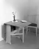 Klaffbord, stol, blomvas och keramiktallrik. Den 18 oktober. Ahrnebergs