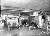 Interiör från verkstaden, 22 maj 1946. Valbo Verkstad A-B grundades år 1923 av häradsdomare  K. G. Ålenius  . Denne övertog ett tidigare bildat bolag, som drev verkstadsrörelse i Valbo med tillverkning av arbetsvagnar, timmerkälkar m. m. lät nu omlägga rörelsen för tillverkning av bil karosserier, varav mest lastvagns- och skåpbilskarosserier tillverkas. År 1929 ombildades firman till aktiebolag med Ålenius som verkst. direktör. Vid sin död år 1938 efterträddes han av sonen, ingenjör  Gunnar Ålenius  . Företaget har gått en kraftig utveckling till mötes och kan nu räkna sig till landets ledande inom sin bransch. Från att ha sysselsatt 3—4 man äro nu vid full drift cirka 80 arbetare anställda inom företaget.  Valbo Verkstads A-B omfattar smides-, plåtslageri- och snickeriverkstad, monteringshall, måleri- samt lackerings- och tapetserarverkstäder, alla försedda med moderna, maskinella utrustningar. Bland företagets kunder kunna nämnas: Svenska armén, Kungl. Telegrafverket — över 200 skåpkarosserier ha under årens lopp levererats hit — Postverket, Vattenfallsstyrelsen, Stockholms stads gatukontor, en hel del allmänna verk och inrättningar samt privata företag. Dessutom är bolaget huvudleverantör till flera av de större bilfirmorna i Stockholm samt Ålenius valen förutseende man, som med öppen blick följde utvecklingen inom bilbranschen och han på övriga platser i landet. Företaget höll ut till någon gång på 1980-talet.