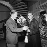 En Kvinna står med en blombukett vid öppnandet av Varuhuset EPA i Huskvarna.