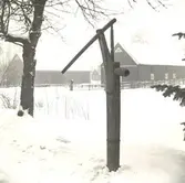 Nyebo brunn.
Pump av trä, använd vid hälsobrunnen.