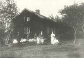 En familj står uppställd framför sitt hem Viborg 1913.