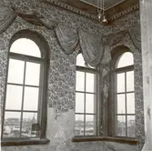 Översta våningen i huset vid korsningen Proviantgatan - Skeppsbrogatan. Gardinuppsättning i gulbrunt siden.