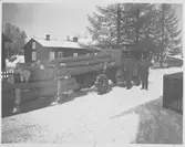 Två män. invid en timmerlastbil.