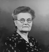 Porträtt av kvinna med glasögon.