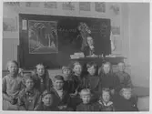 En skolklass, med sin lärarina.