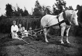 En familj, tar en paus i slåtterarbetet.