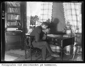 Fotografen vid skrivbordet på kammaren.