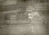 Flygbild visande herrgården närmast samt den övriga byn mellan herrgården och vägskälet.